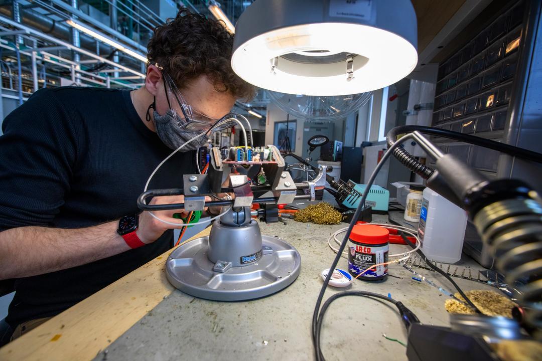 A person working on wiring in a laboratory setting